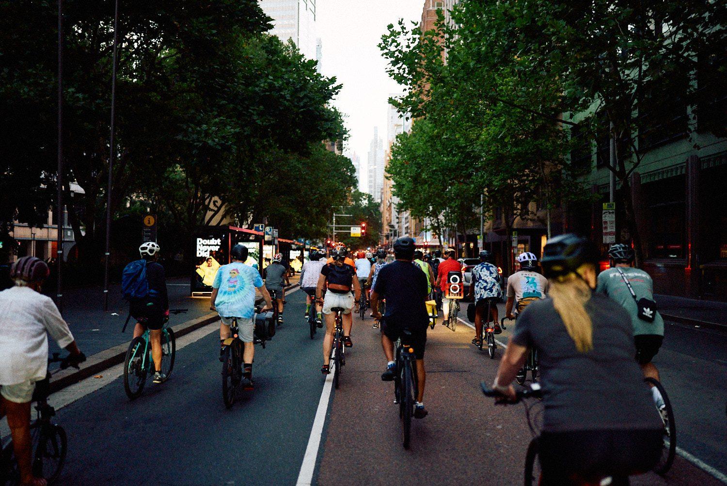 Hundreds of riders filling a Sydney street at golden hour