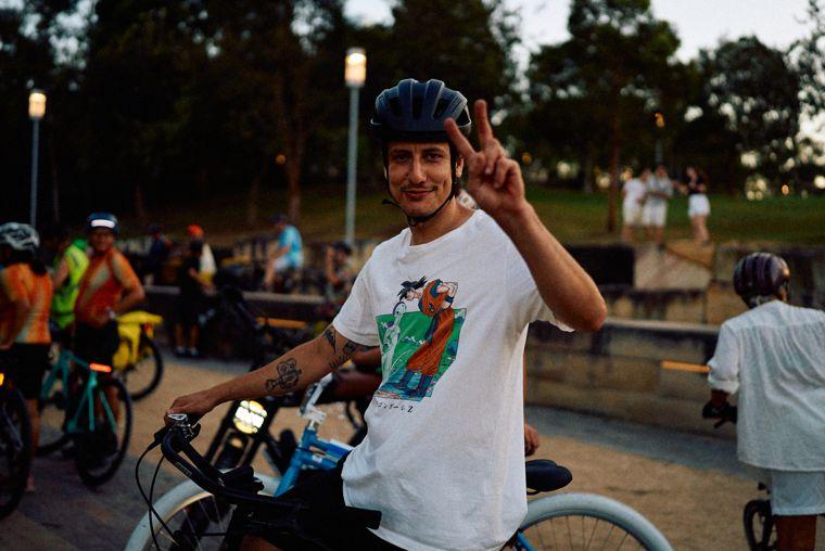 A rider throws a peace sign at the meet point at dusk